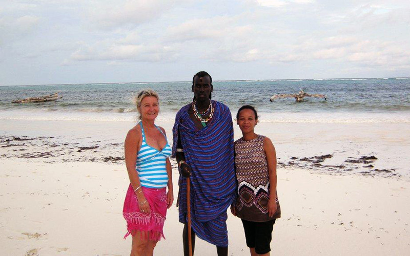 Nadine and colleague Jenniveve with a Masai warrior on a beach in Zanzibar